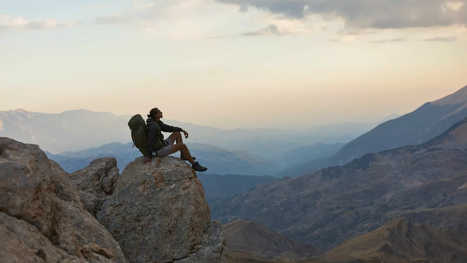 Backpacker rests on a rock