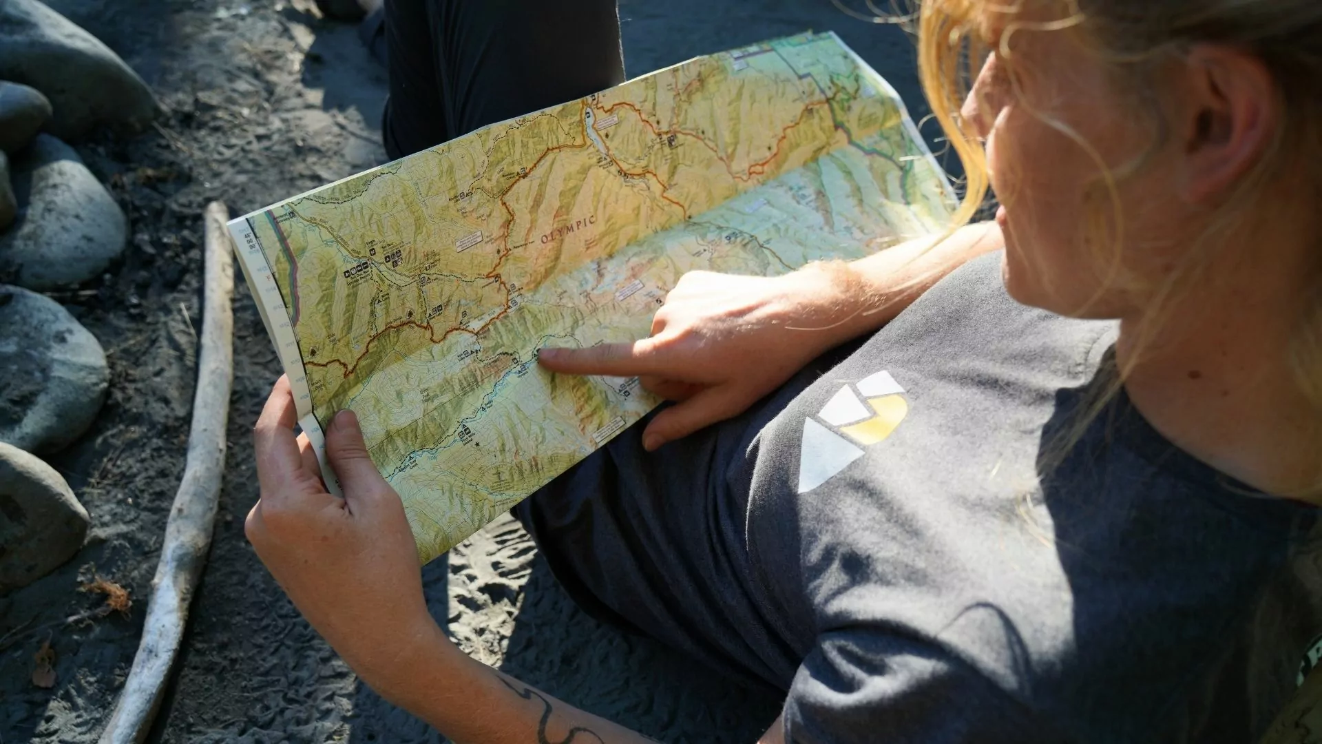 A woman points at a spot on a topographic map