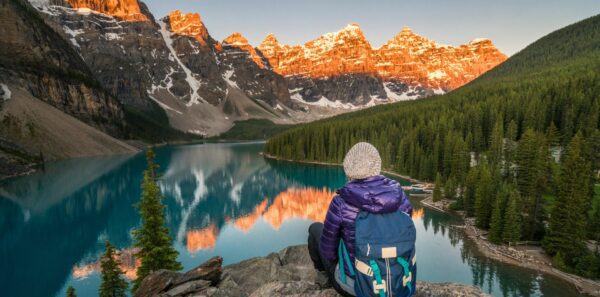 A hiker sits overlooking a lake in Banff National Park