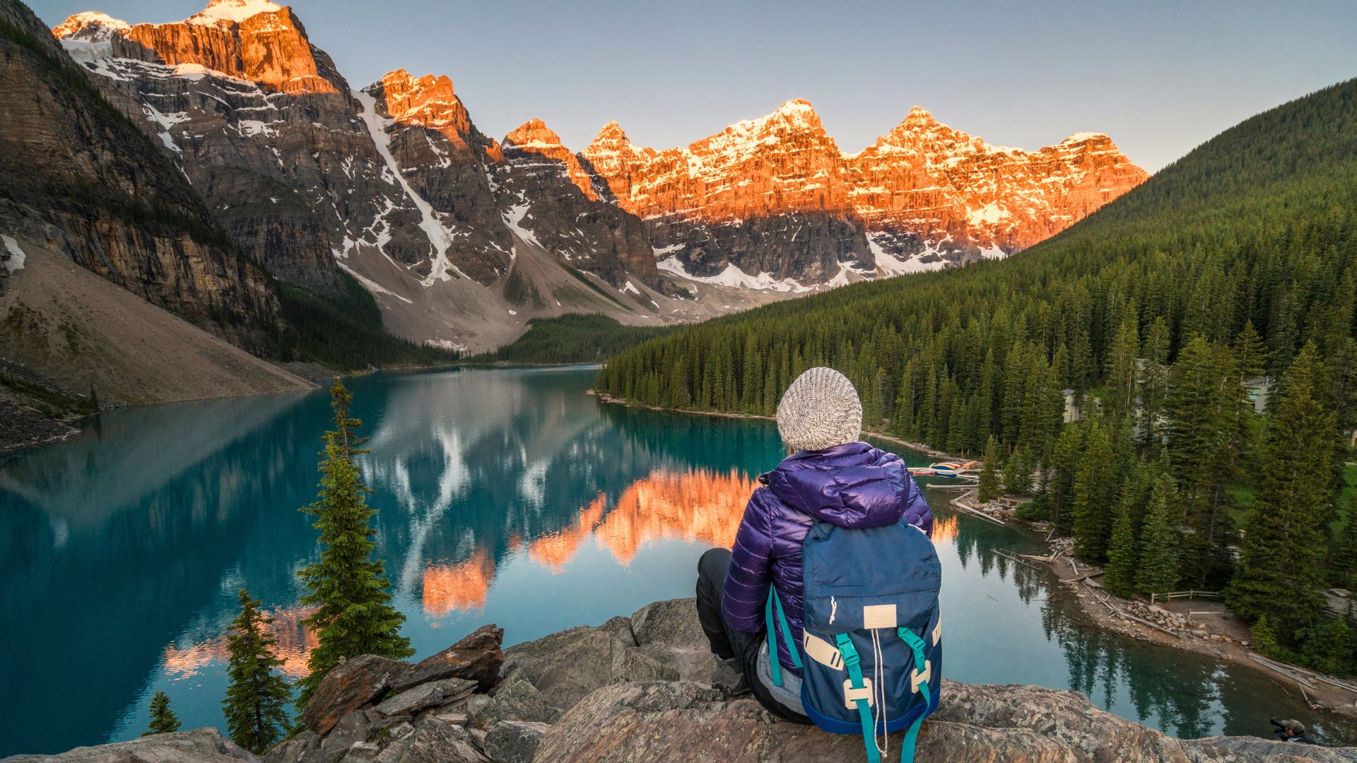 A hiker sits overlooking a lake in Banff National Park