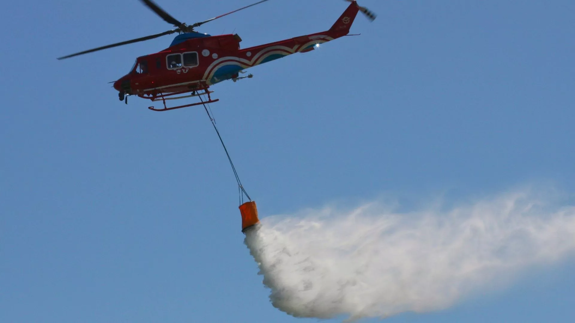 A firefighting helicopter drops fire retardant