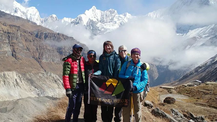 Hikers holding Wildland Trekking flag on mountain