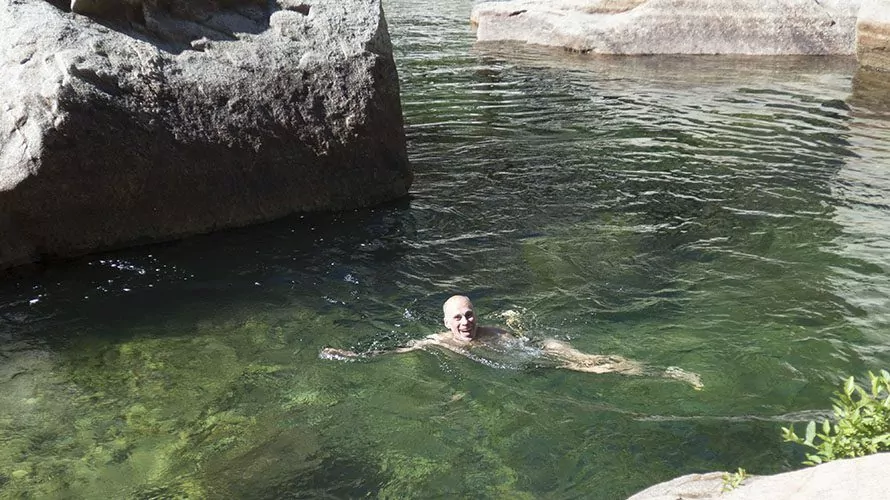 man swimming in green natural water