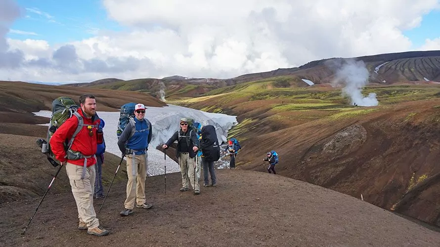 Hikers descending down a dirt hill