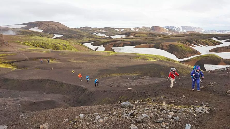Hikers walking over hilly earth