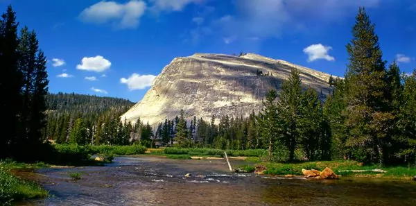 Incredible stone mountain behind river and lush green