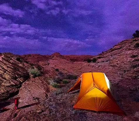 Backpacking Under the Stars - Tent lit up with stars in desert canyons in Southwest Utah USA.