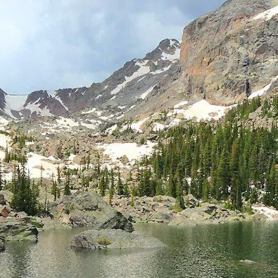 The granite rock formations dappled in snow and pine trees in Rocky Mountain National Park