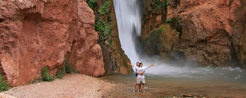 Hikers in front of waterfall