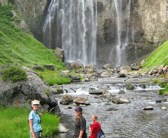 hikers by waterfall at yellowstone