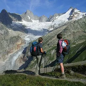 Two hikers before large glacier