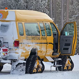 A Yellowstone official snow vehicle pauses roadside.