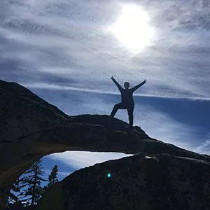 A hiker poses for a summit photo in yosemite national park