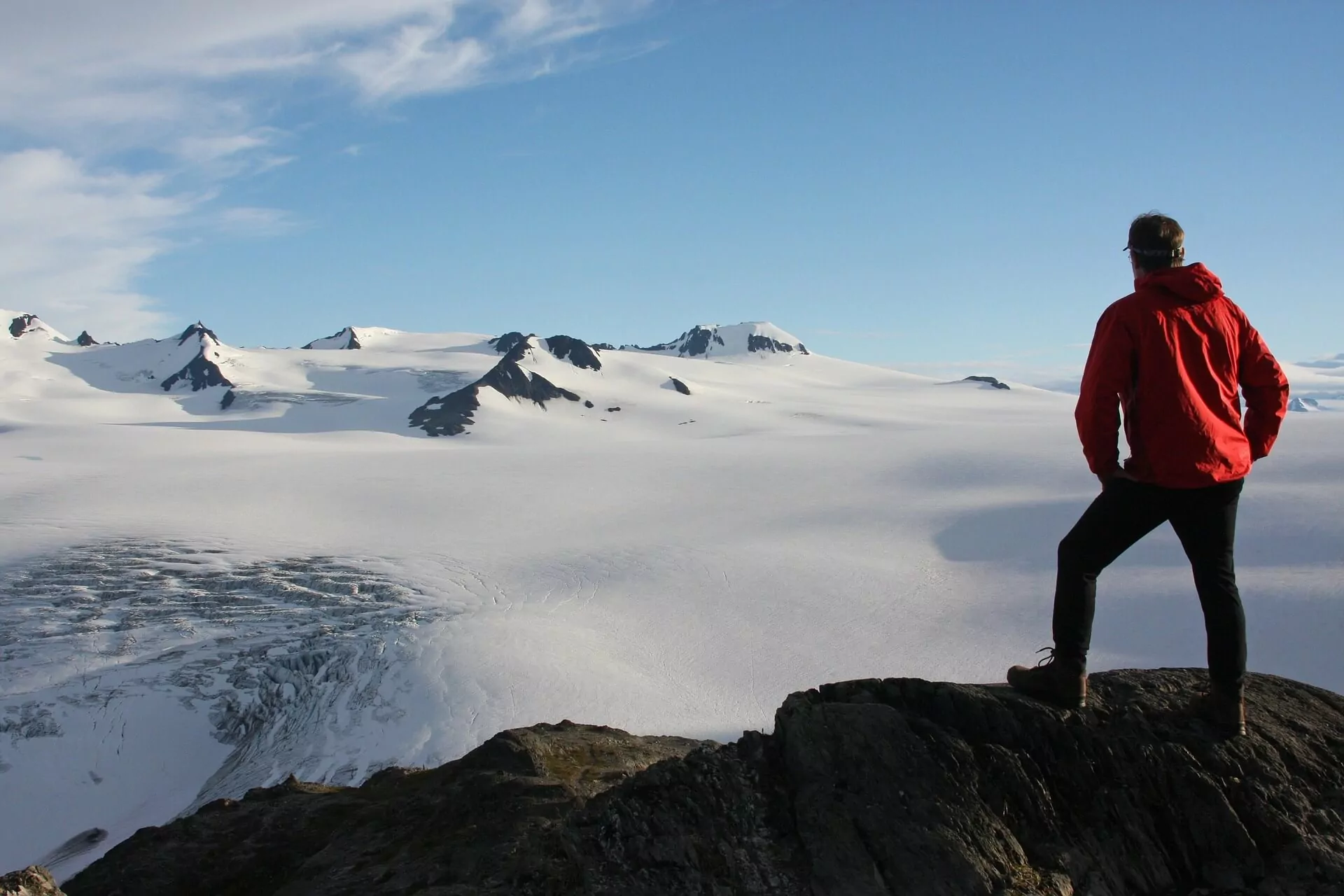A hiker looking out at the Exit Glacier in Fjords National Park, Alaska