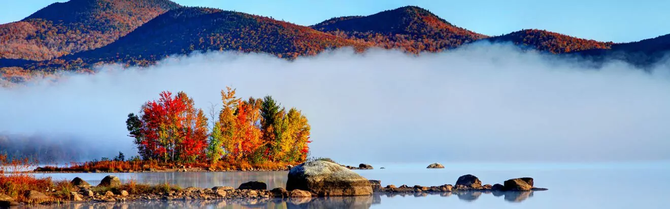 Early morning autumn in the Green Mountain National Forest in Vermont. Photo taken on a calm foggy colorful morning during the peak autumn foliage season. Vermont's beautiful fall foliage ranks with the best in New England bringing out some of the most colorful foliage in the United States