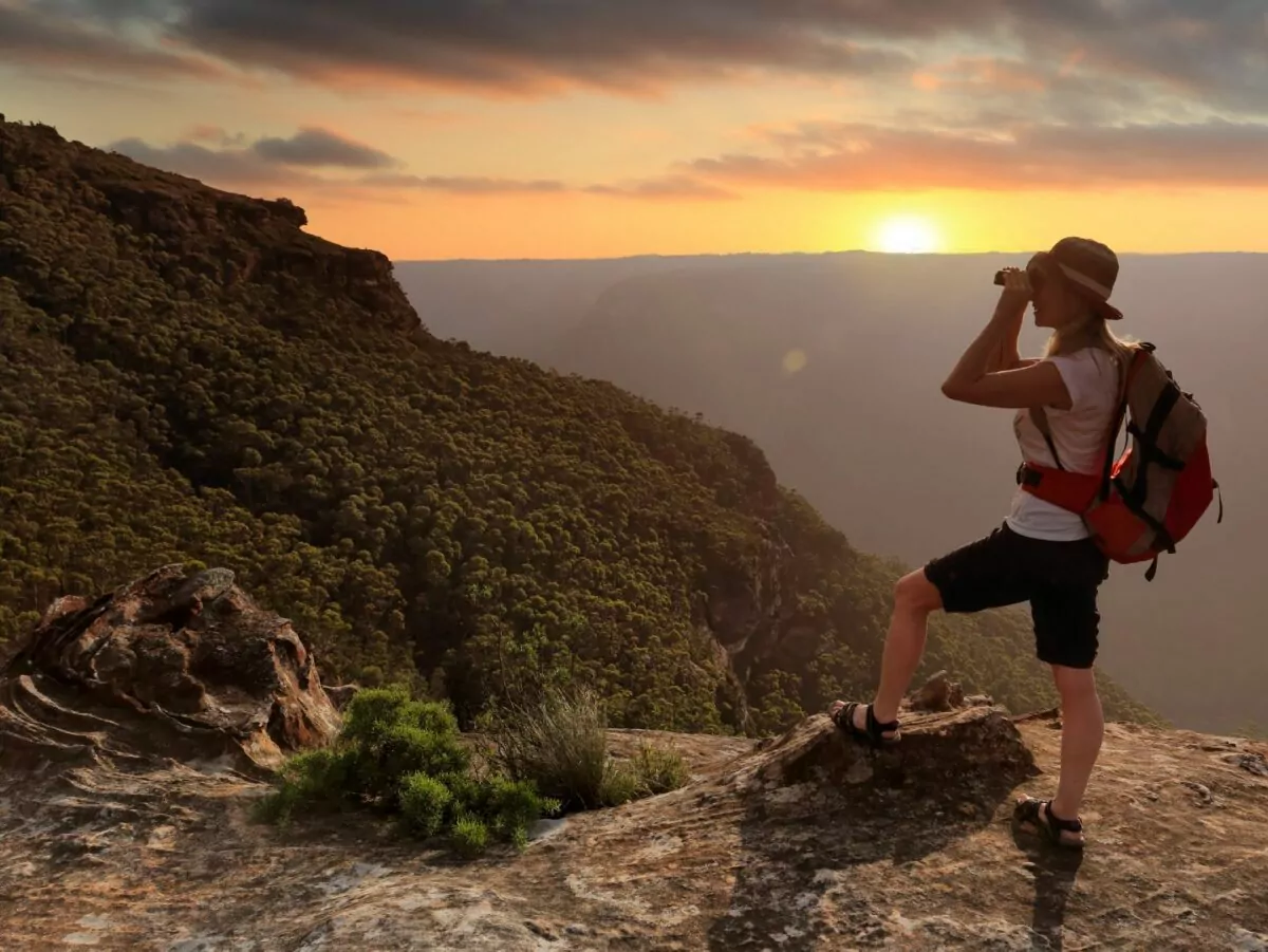Female hiker spots wildlife on a mountain pass