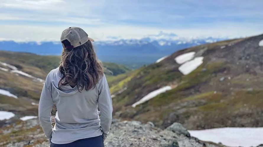 Woman standing looking at Denali Peak from K'esugi Ridge