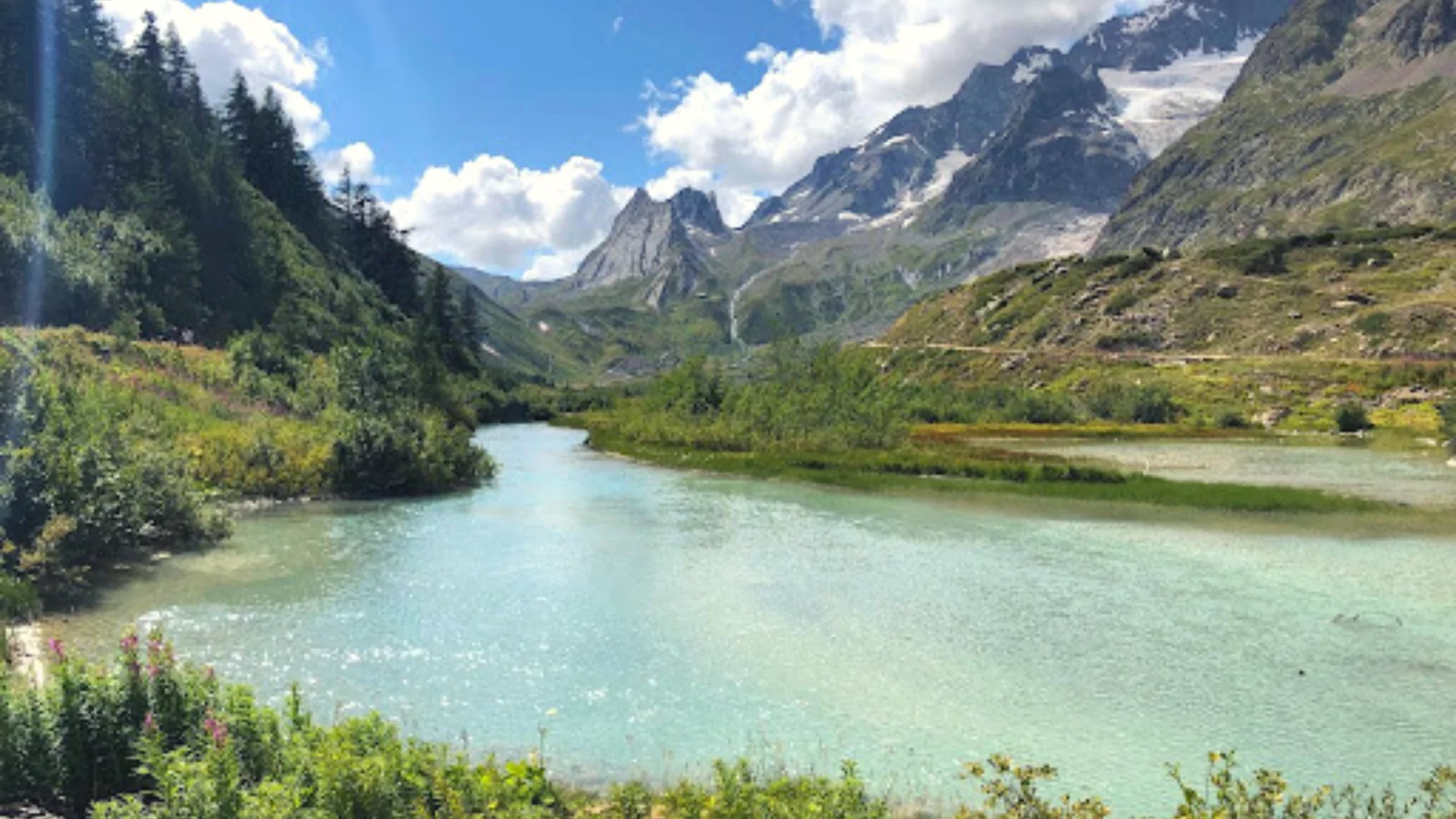Riverside view of the mountain peaks of the Alps