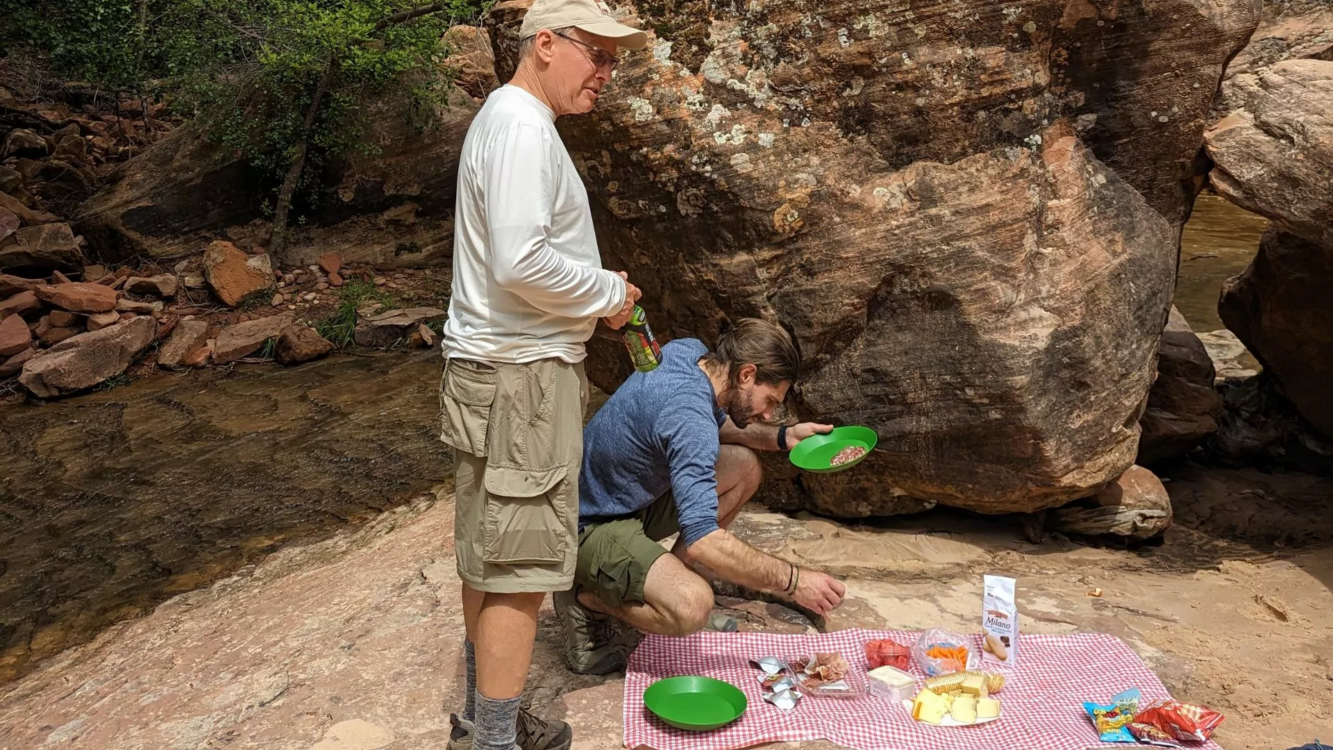 Two hikers enjoy a picnic spread