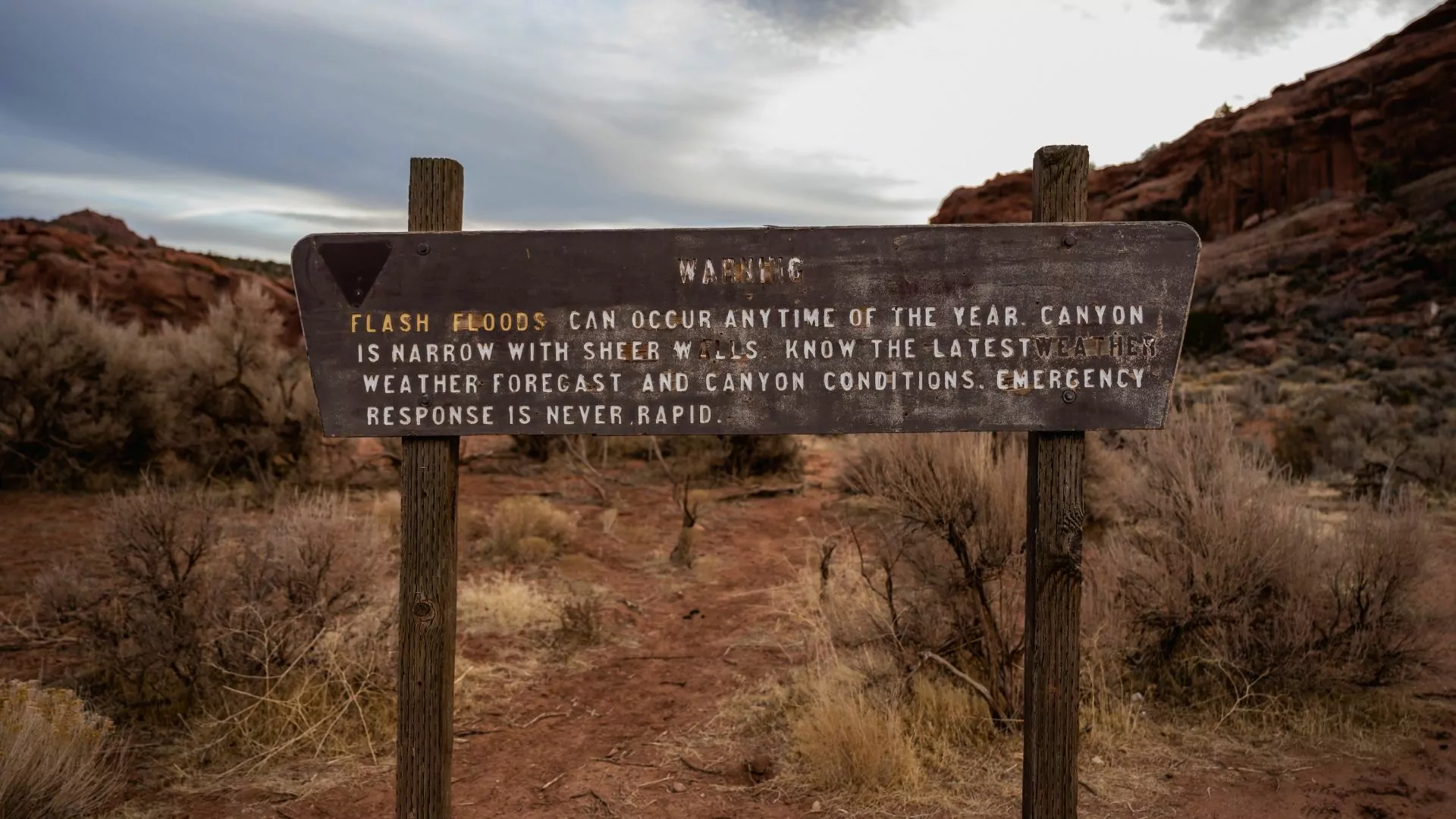 A flash flood warning sign marks the start of a hike