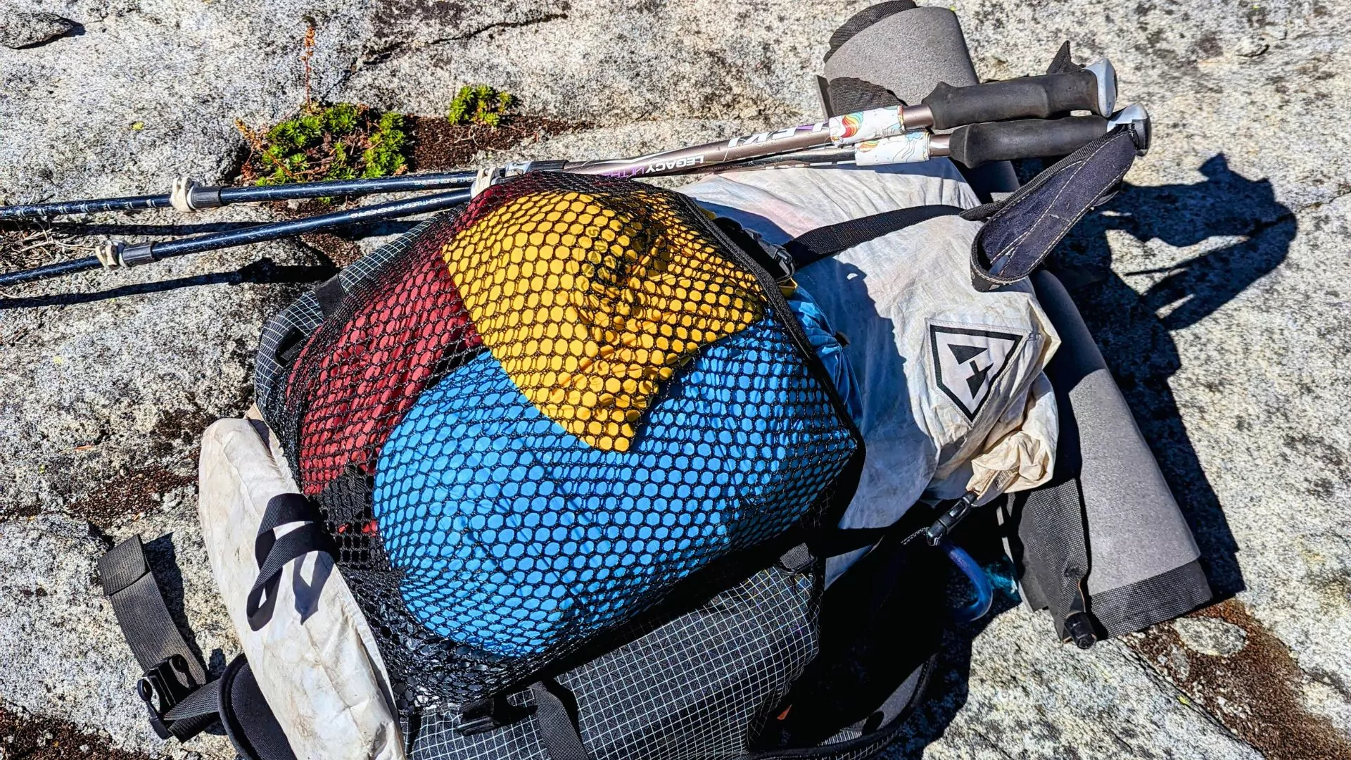 A hyperlite mountain gear back lays fully loaded on a rocky surface