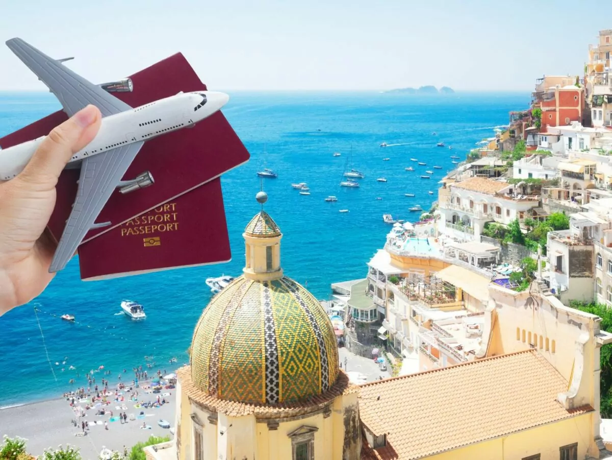 A traveler holds up a passport in front of an exotic seaside location