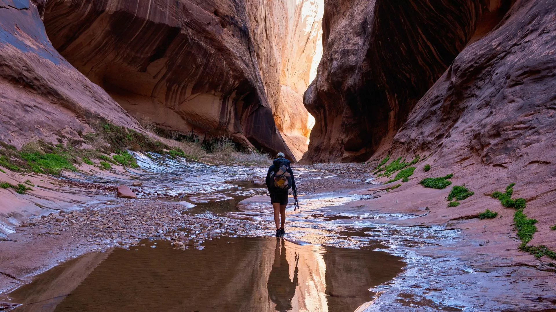 A hiker backpacks through a canyon