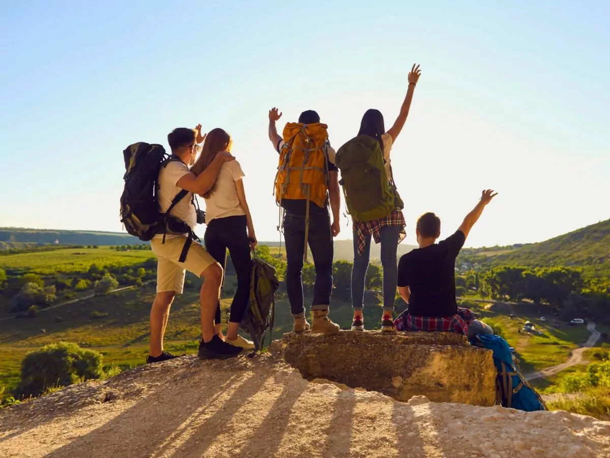 A group of hikers pose at a summit