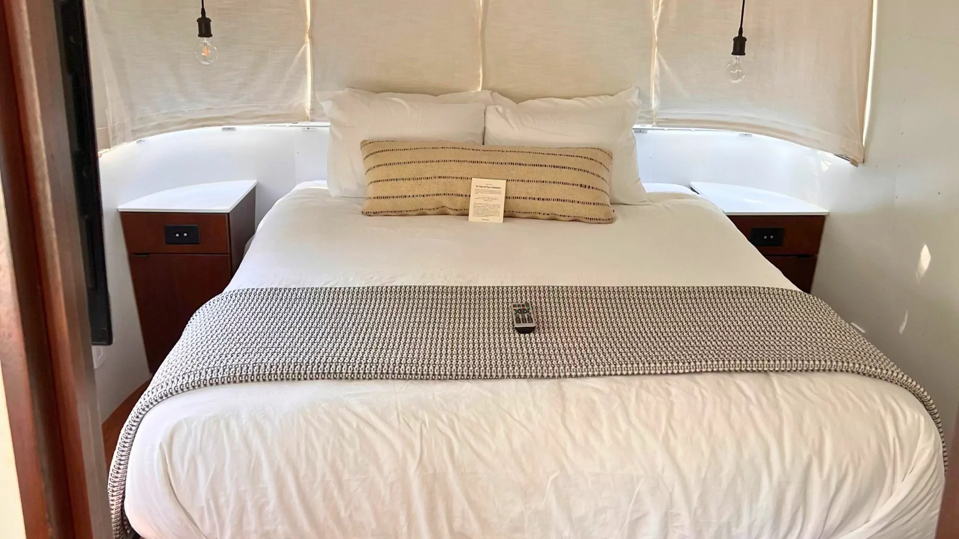 A well made bed fits in a cozy airstream trailer