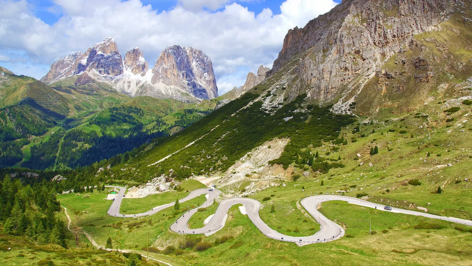A road winds through a mountain valley in the Dolomites