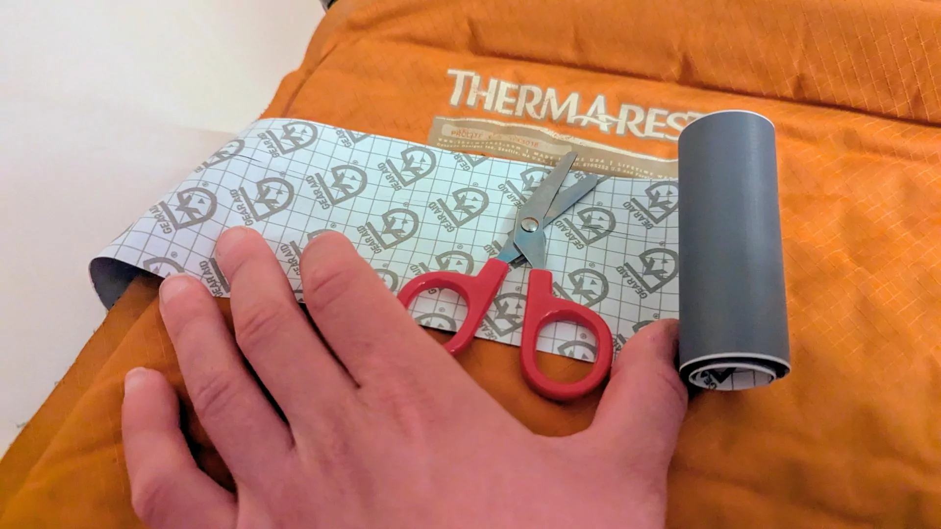 An inflatable sleeping pad with scissors and patch kit