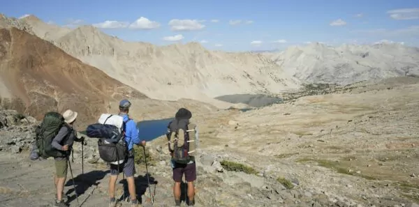Three backpackers look at the mountains
