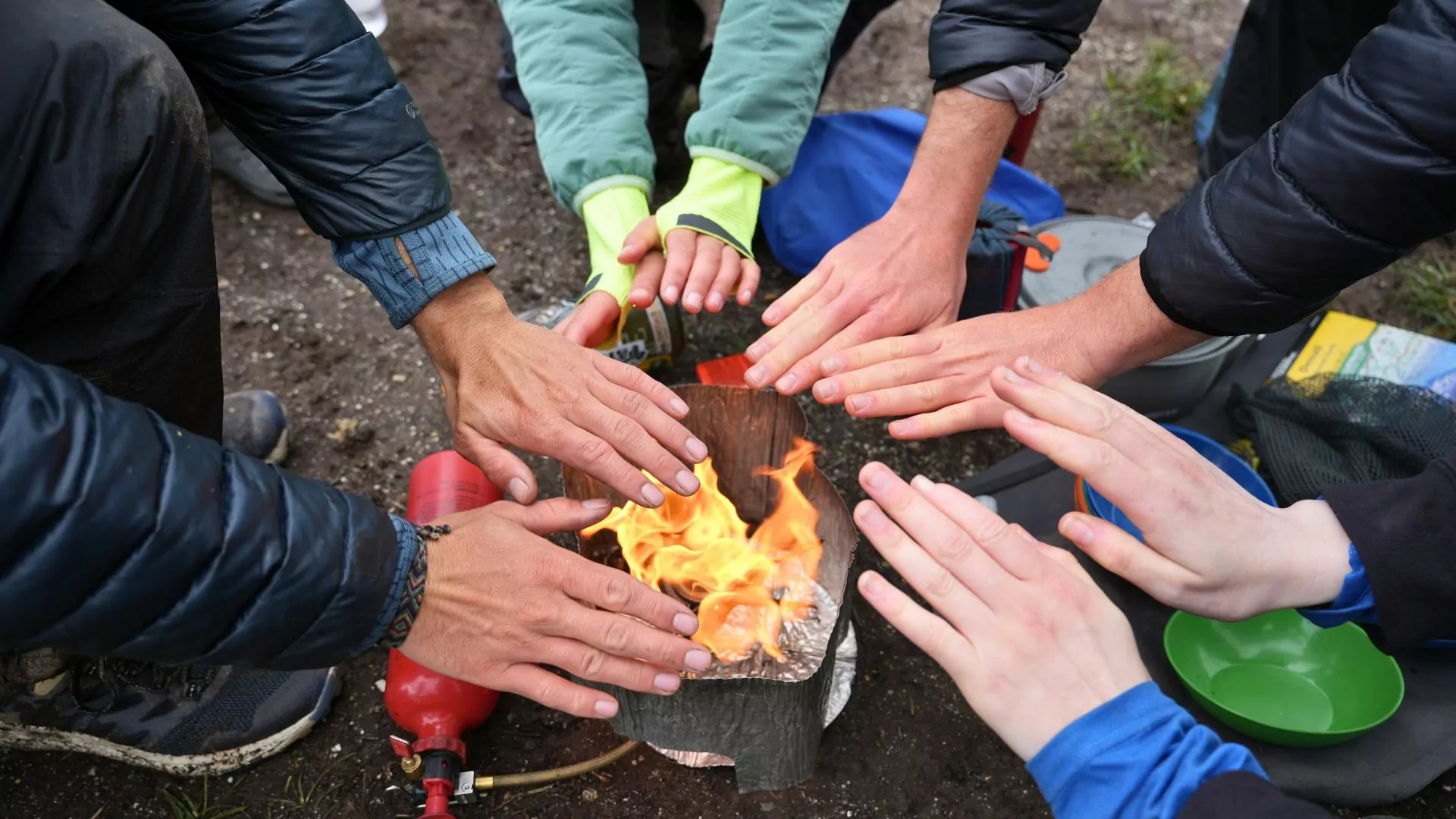 People warm their hands by a fire