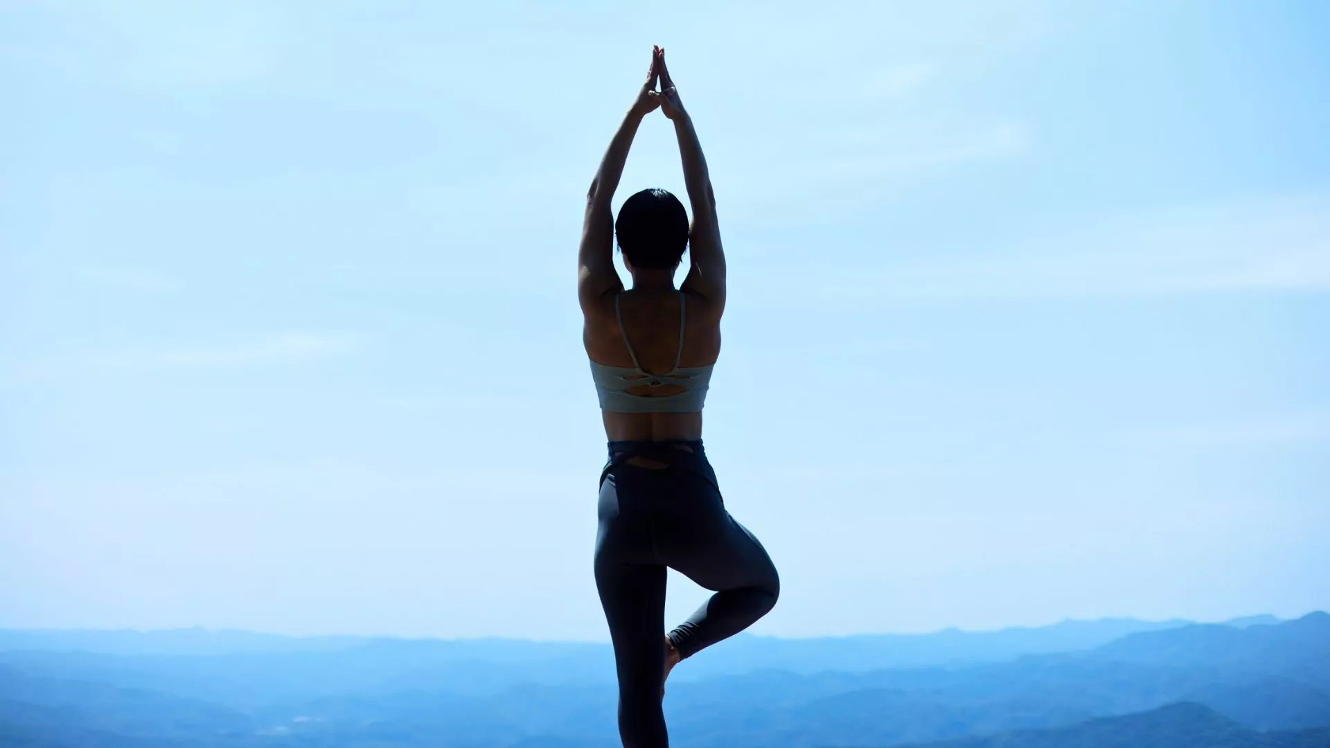 A woman does a yoga pose outdoors