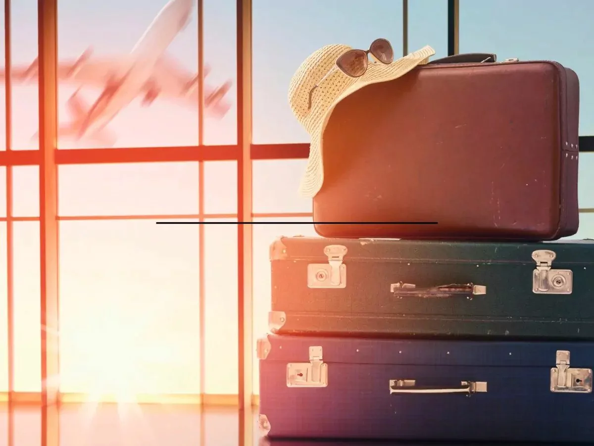 Suitcases are stacked in the airport|The Yellowstone National Park sign is buried in snow|A woman with luggage stands looking at a plane during take off|A man looks at a map|Family road trip