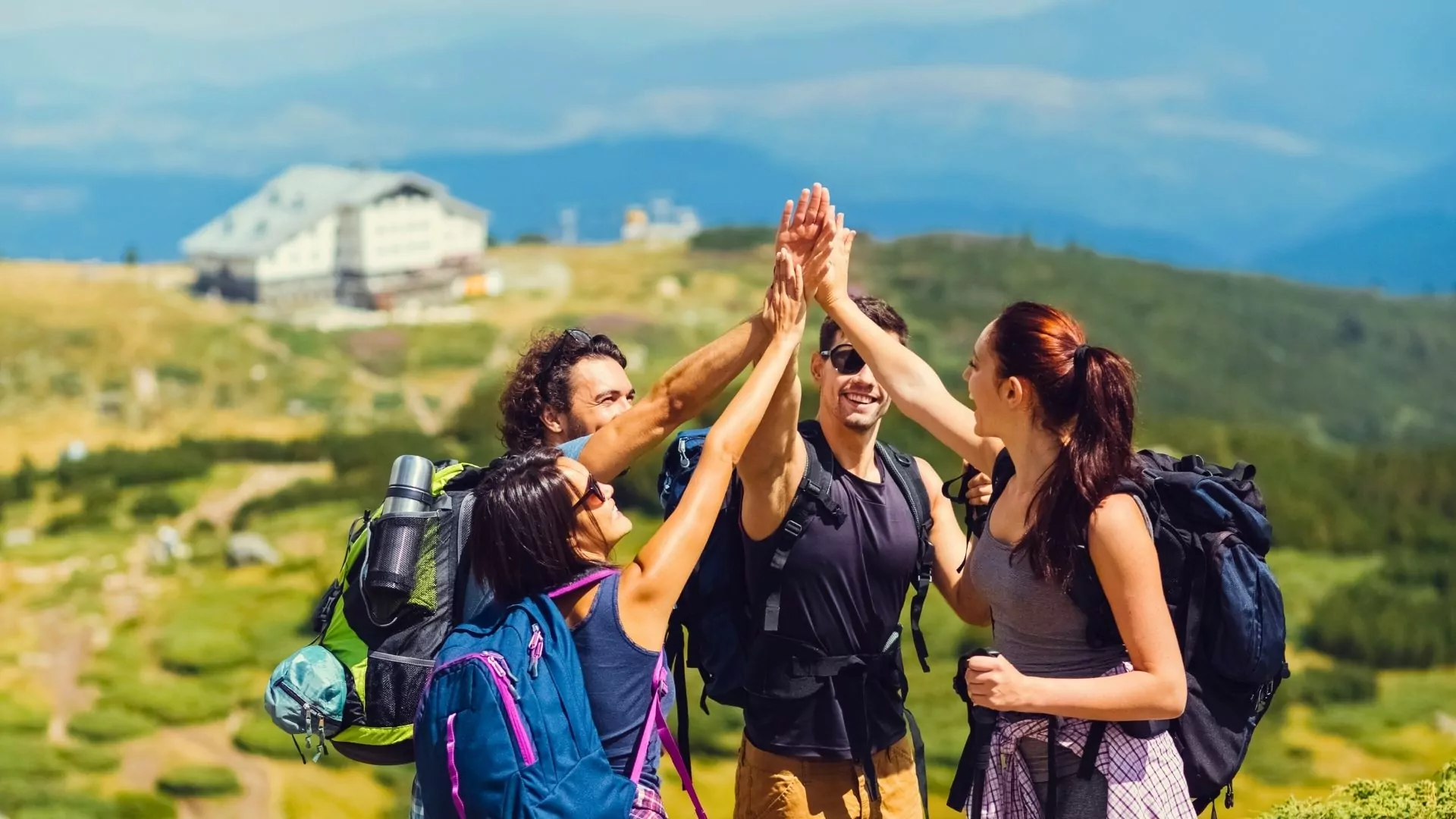 A group of hikers high five each other