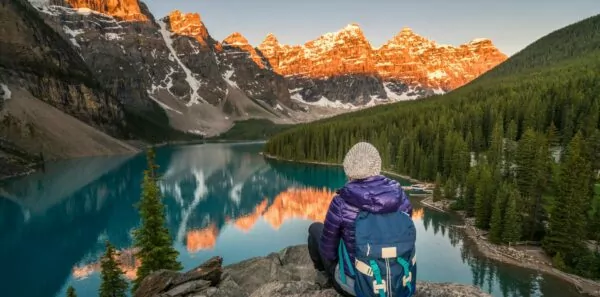 A hiker sits overlooking a lake in Banff National Park